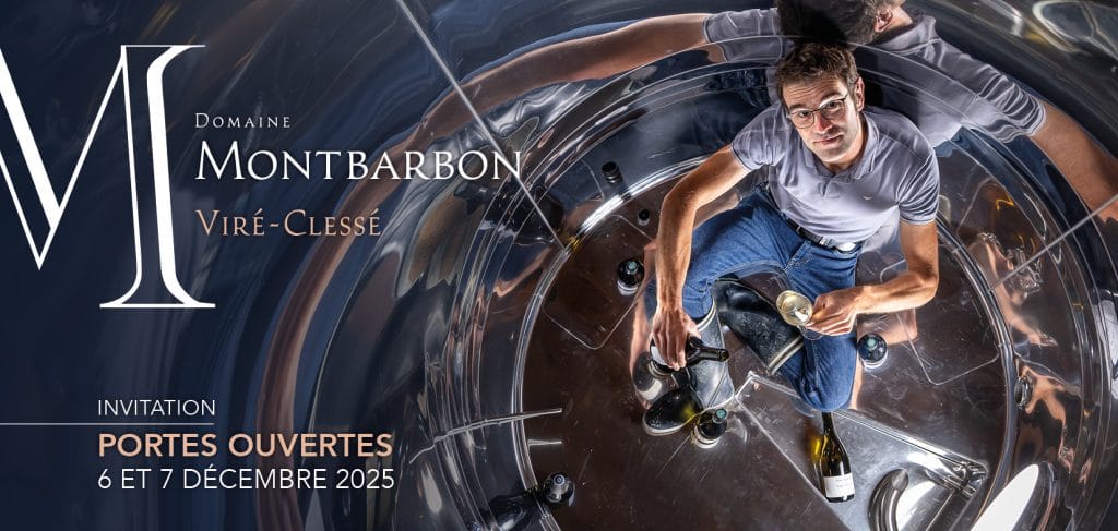 Un homme tenant un verre de vin dans une cuve de fermentation au Domaine Montbarbon.